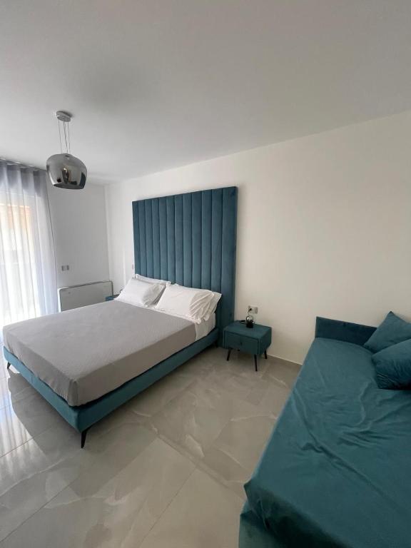 a bedroom with a large bed and a couch at Gheloi Room in Gela