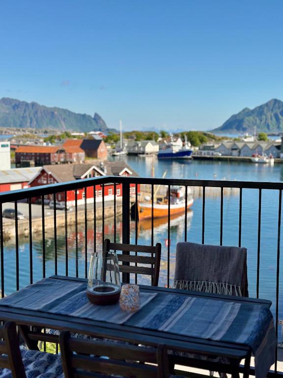 a table and chairs on a balcony with a view of the water at Mountain and Sea View Svolvær in Svolvær