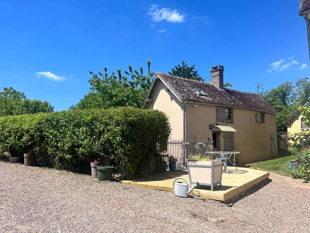 a house with a table and a bench in front of it at Gîte des sabotiers in Le Boissenet