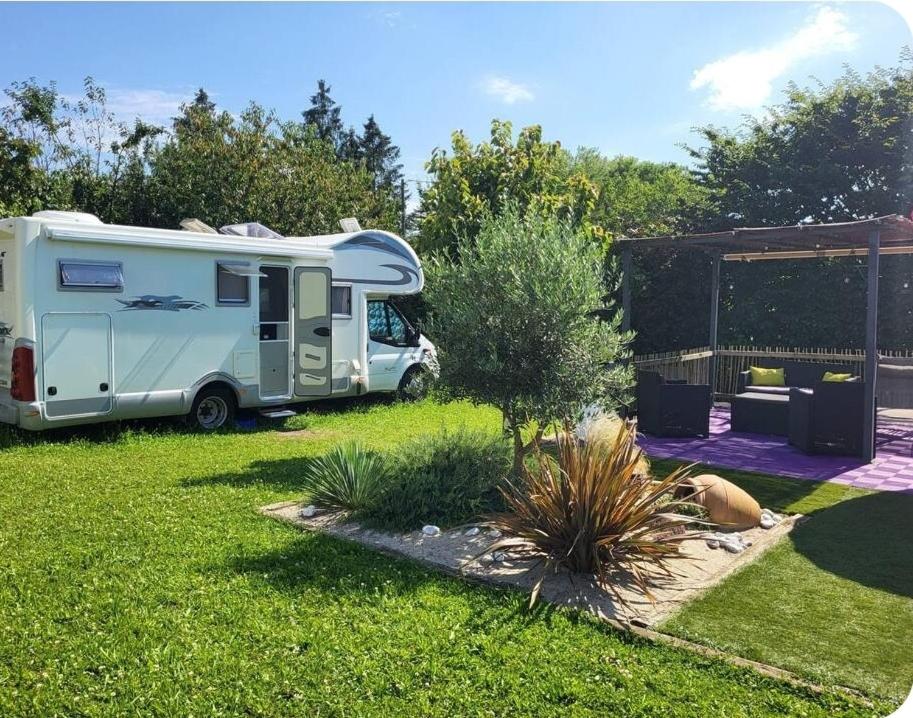 a caravan parked in a yard next to a garden at Le Maillotin en balade in Les Maillys