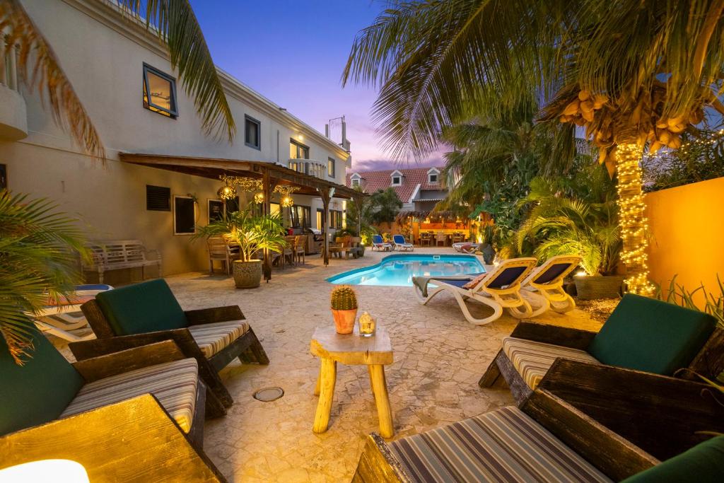 a backyard with a pool and chairs and a table at Oasis guesthouse, Boutique Style Hotel in Kralendijk