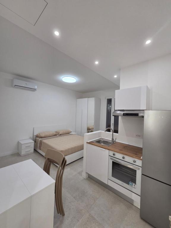 a white kitchen with a bed in a room at Dimore Marche Porto Recanati in Porto Recanati
