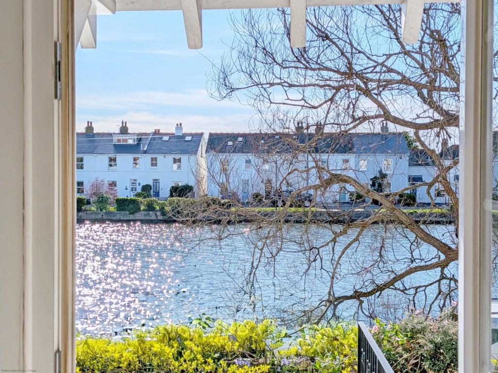 a window with a view of the water and buildings at Thimble Cottage - Emsworth in Emsworth