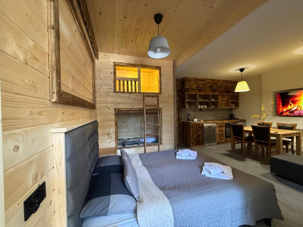 a bedroom with a bed and a dining room at Apartament Rodzinny Deluxe in Poronin