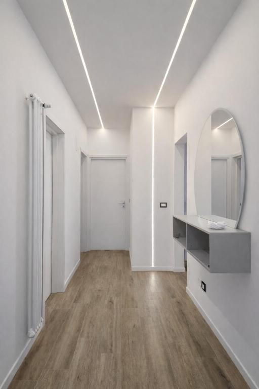 a white bathroom with a sink and a mirror at Central Chic Apartment in Imola