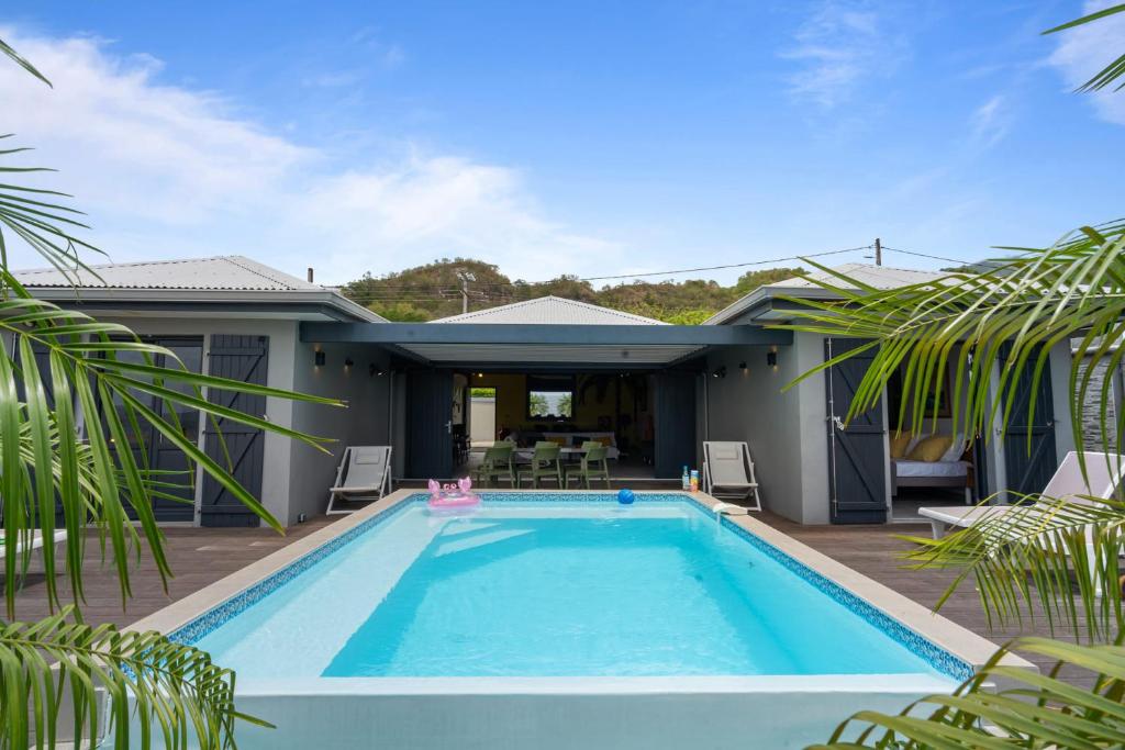 a swimming pool in the backyard of a house at Villa lEscale de Sainte Philomène in Saint-Pierre