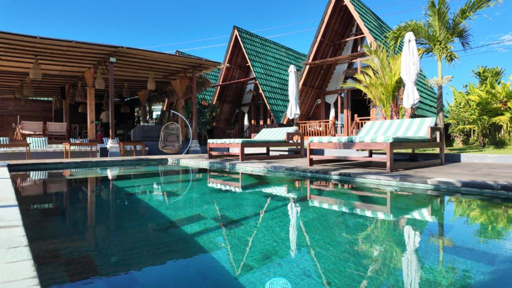 a pool at a resort with two lounge chairs at Cascadia Rad Villa in Jatiluwih