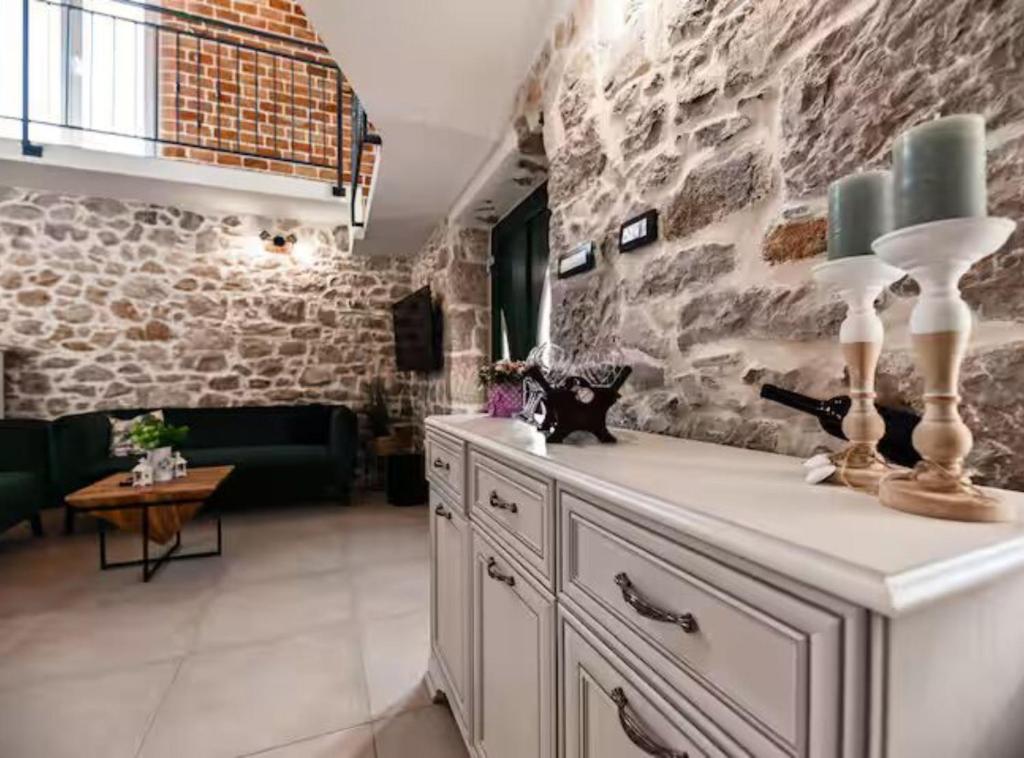 a room with a stone wall with two lamps on a dresser at La Felicita in Gornji Zemunik