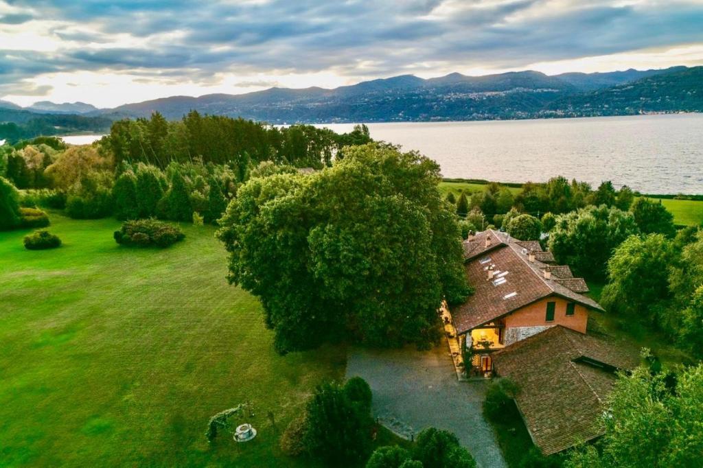 an old house in a field next to a lake at Tenuta La Quassa in Ispra