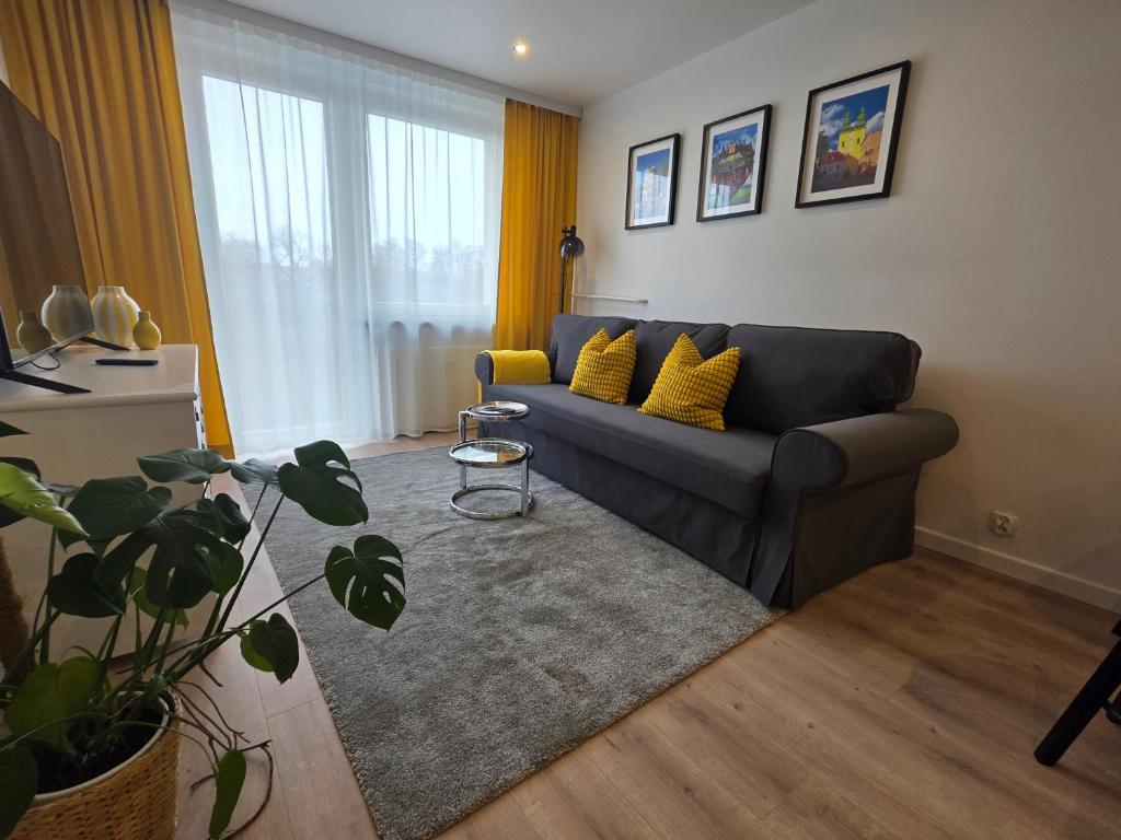 a living room with a couch and yellow pillows at Perełka Południa in Głuchołazy