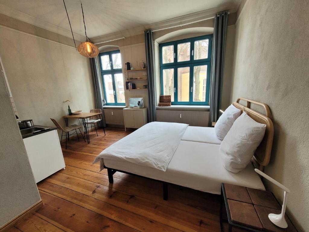 a bedroom with a bed and a table and windows at Lioba in Ueckermünde