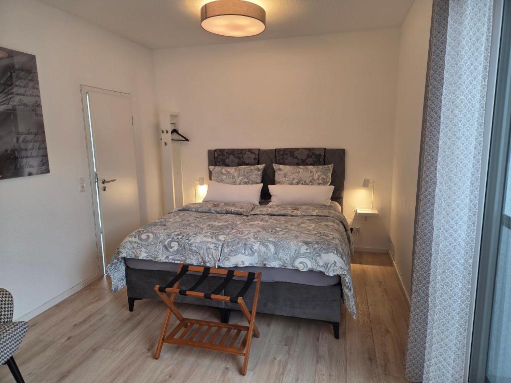 a bedroom with a large bed and a chair at Neues Ruhrtal Apartment 4 mit Balkon in Wickede (Ruhr)