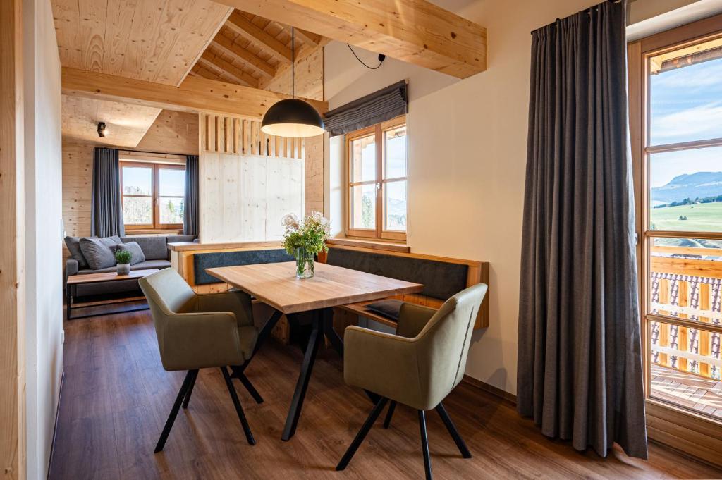 a dining room with a wooden table and chairs at Alpenrose in Obermaiselstein