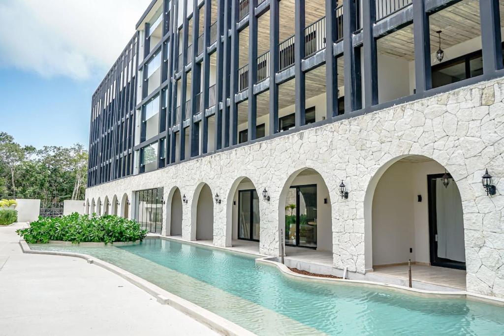 an external view of a building with a swimming pool at Jungle View Nest Selva Rooftop in Tulum