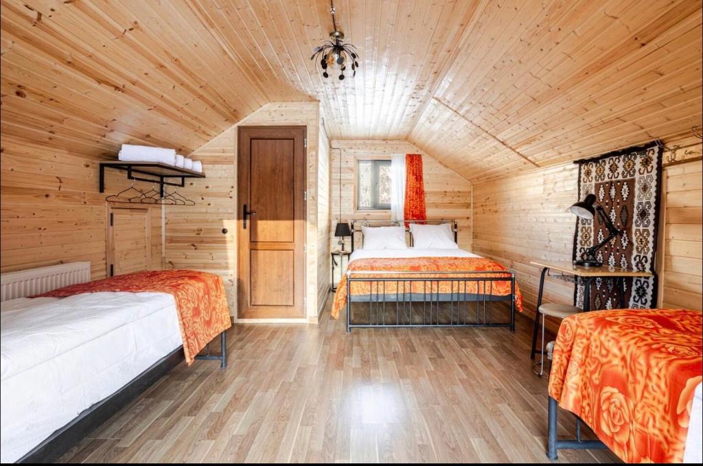 a bedroom with two beds in a wooden cabin at SetAura Kazbegi in Kazbegi