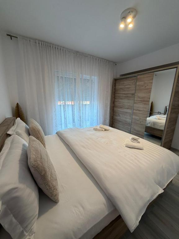 a large white bed in a bedroom with a mirror at Natalia Apart in Alba Iulia