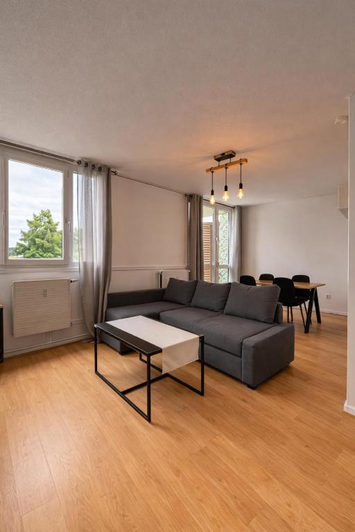 a living room with a couch and a table at Beau duplex lumineux avec balcon in Chalon-sur-Saône