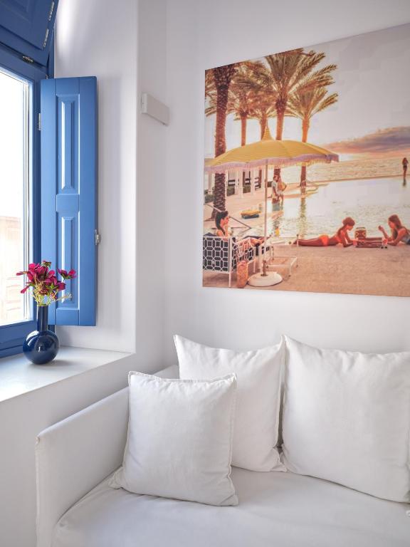 a living room with a white couch and a painting at Chiara Mykonos in Mikonos