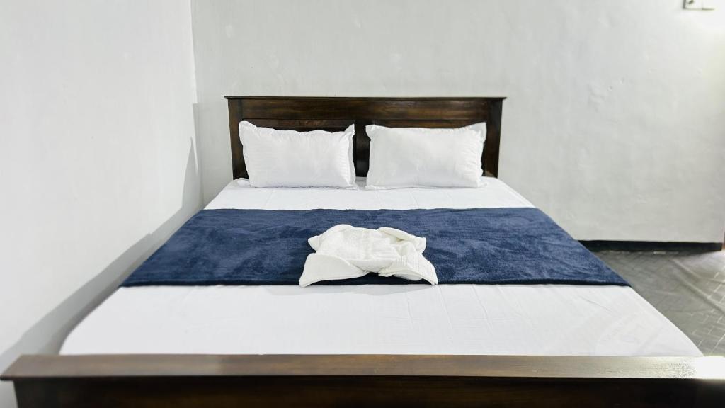 a bed with a blue and white blanket and pillows at Livora Mountain Lodge in Etimole