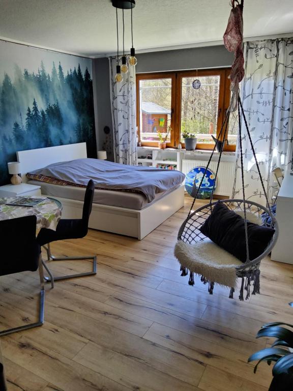 a bedroom with a bed and a swing at Eifelsteigzimmer Bruderherz in Gerolstein