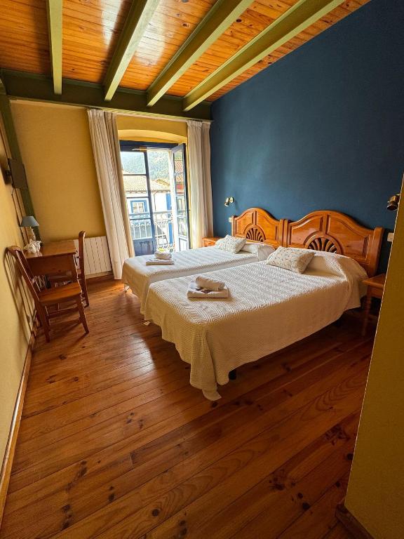 a bedroom with a large bed and a wooden floor at Hotel Cuevas Del Mar in Nueva de Llanes