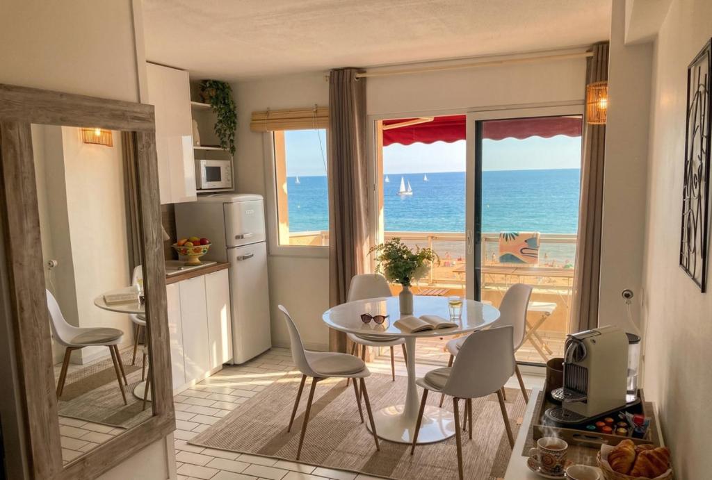 a kitchen with a table and chairs and the ocean at Vue sublime-conciergrie IB in Canet-en-Roussillon