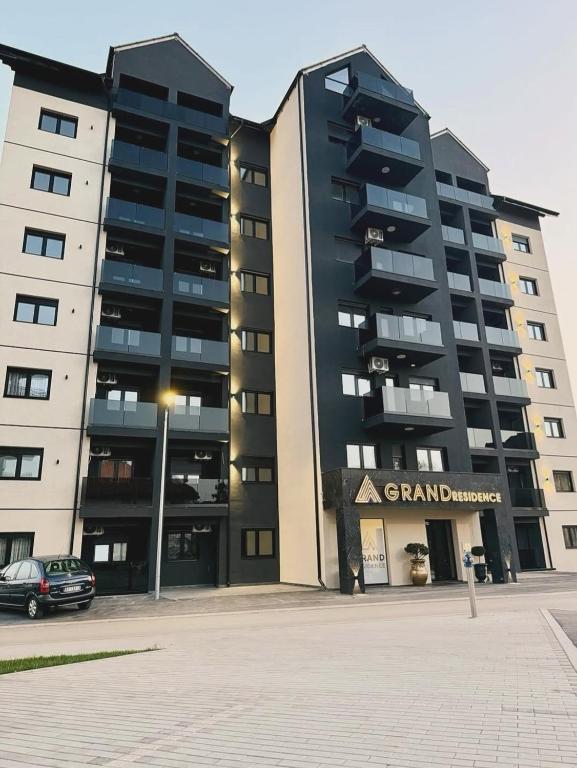 a large building with a car parked in front of it at BK Apartman in Zlatibor