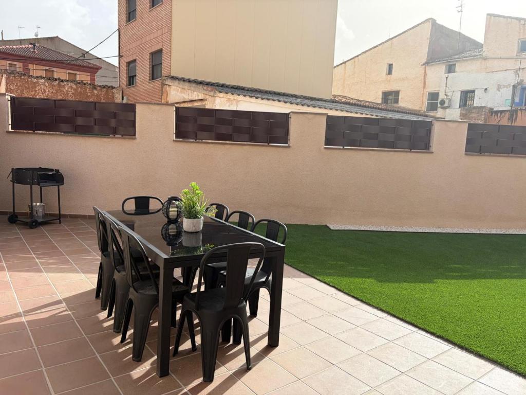 a black table and chairs on a patio with grass at Casa Rural El Cantarero in Ariza