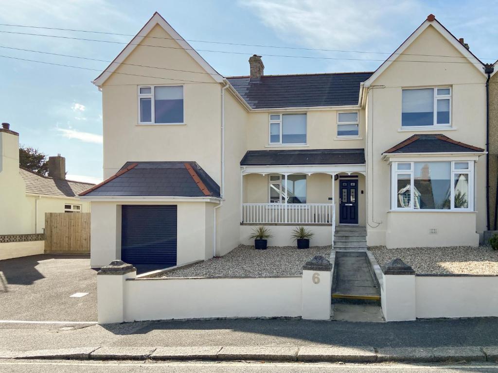 a white house with a driveway at Tolcarne Retreat in Newquay