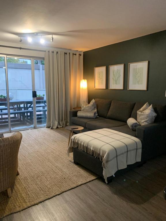 a living room with a couch and a bed at Durbanville Self Catering Apartments in Durbanville