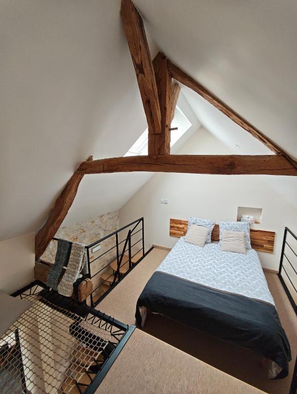 a attic bedroom with a bed and a staircase at Le Box Circuit Magny-Cours in Saint-Parize-le-Châtel