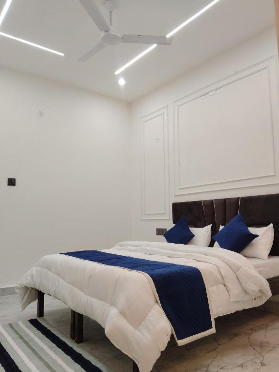 a white bedroom with a large bed with blue pillows at Velley inn hotel & resort in Barkot