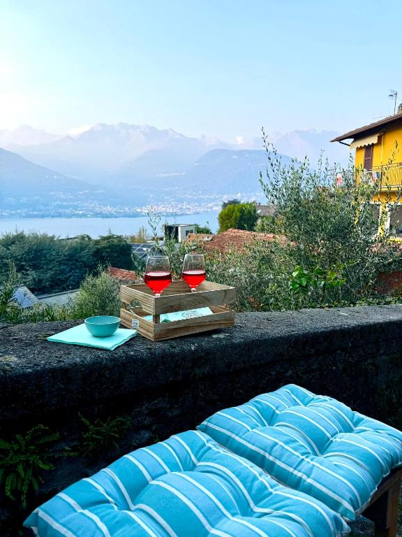 a blue couch with two glasses of wine on a table at Casa Zita Cozy • AC near Lake Como by Gottschalk in Olgiasca
