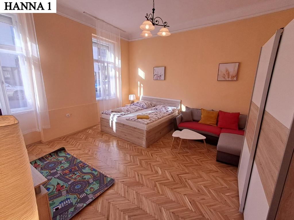 a bedroom with a bed and a couch at Hanna Apartman 1-2 in Kőszeg