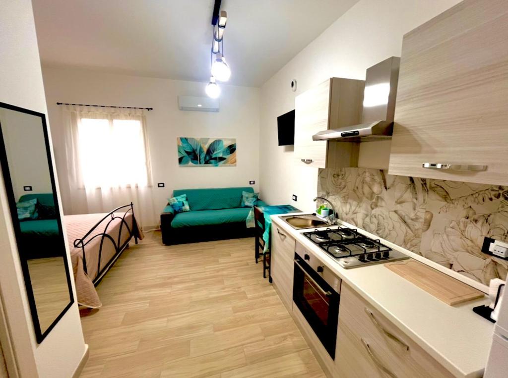 a kitchen and living room with a stove and a couch at Casetta Marisù in Partinico
