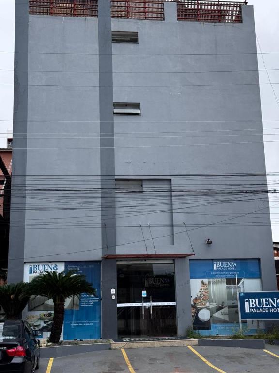 a tall building with a parking lot in front of it at Bueno Palace Hotel in Macapá