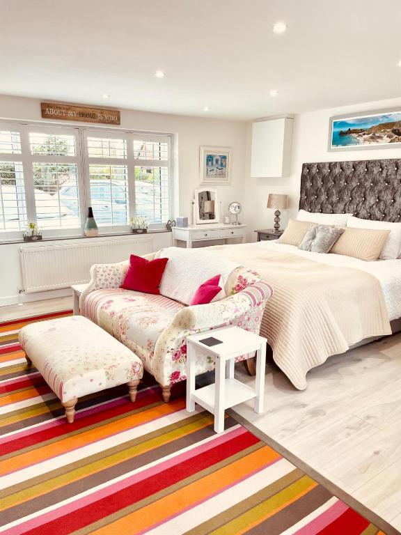 a bedroom with a large bed and a couch at Jayslin in Felpham
