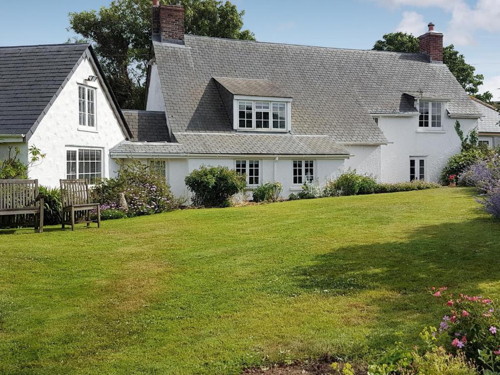 a white house with a large yard at Condurrow Cottage in Saint Anthony