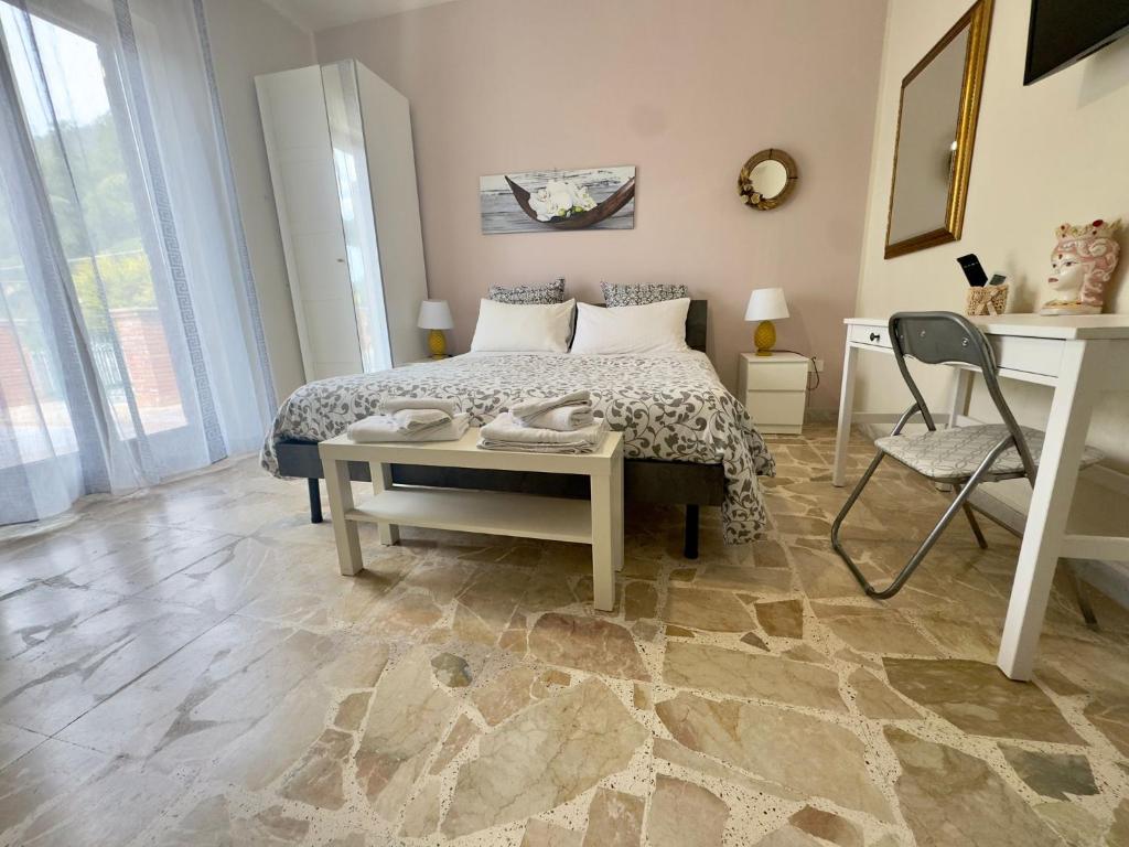 a bedroom with a bed and a table and a desk at Sotto i Monti House in Nicolosi