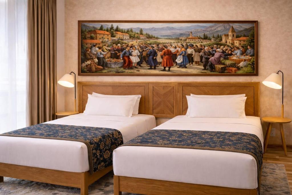two beds in a room with a painting on the wall at Amber Boutique Hotel in Tbilisi City