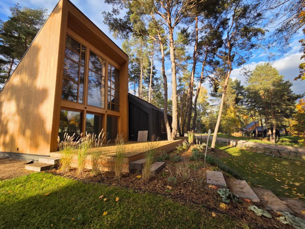 a house with a large window in a garden at Naturelodge Kalbornia Mazury in Dąbrówno