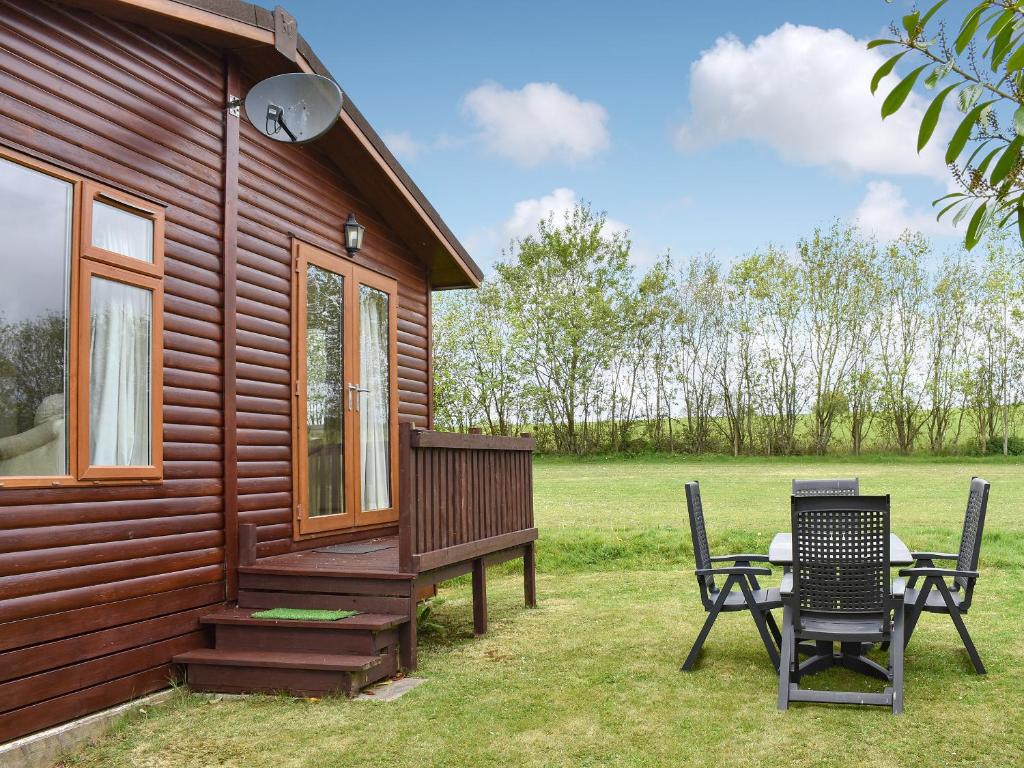 a cabin with a table and chairs outside of it at The Lodge - Uk11271 in Lanreath