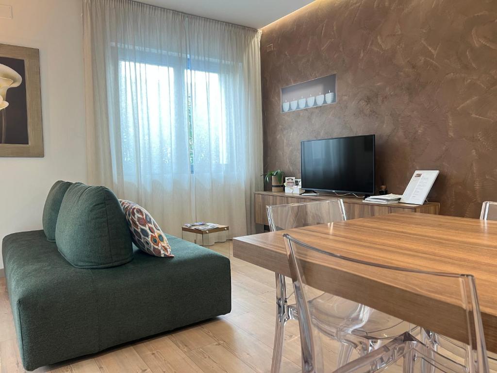 a living room with a green couch and a table at Agordo Suite in Agordo