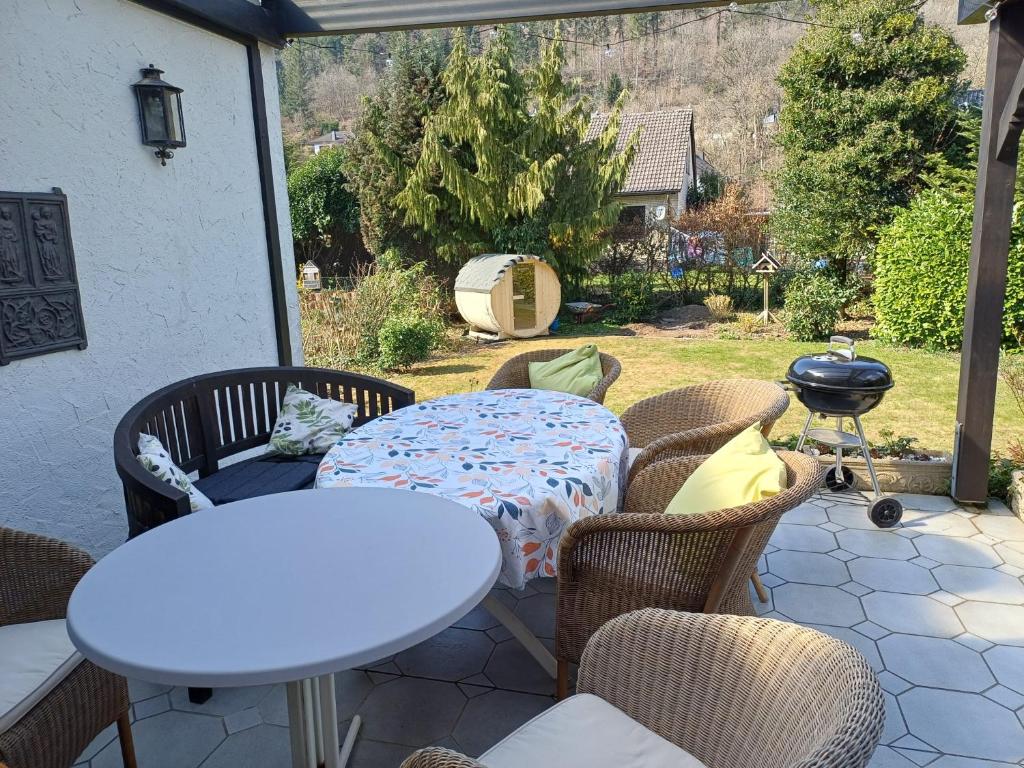a patio with a table and chairs and a grill at ZusammenZeit in Schleiden - inklusive Sauna, Garage, großer Terrasse und 3 Schlafzimmer - ideal für Familien und Freunde - Hunde freundlich in Schleiden