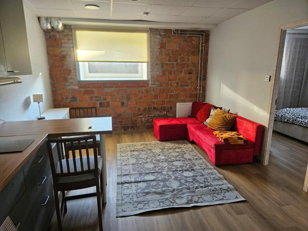 a living room with a red couch and a brick wall at Arbimäe majutus tuba 24 in Elva