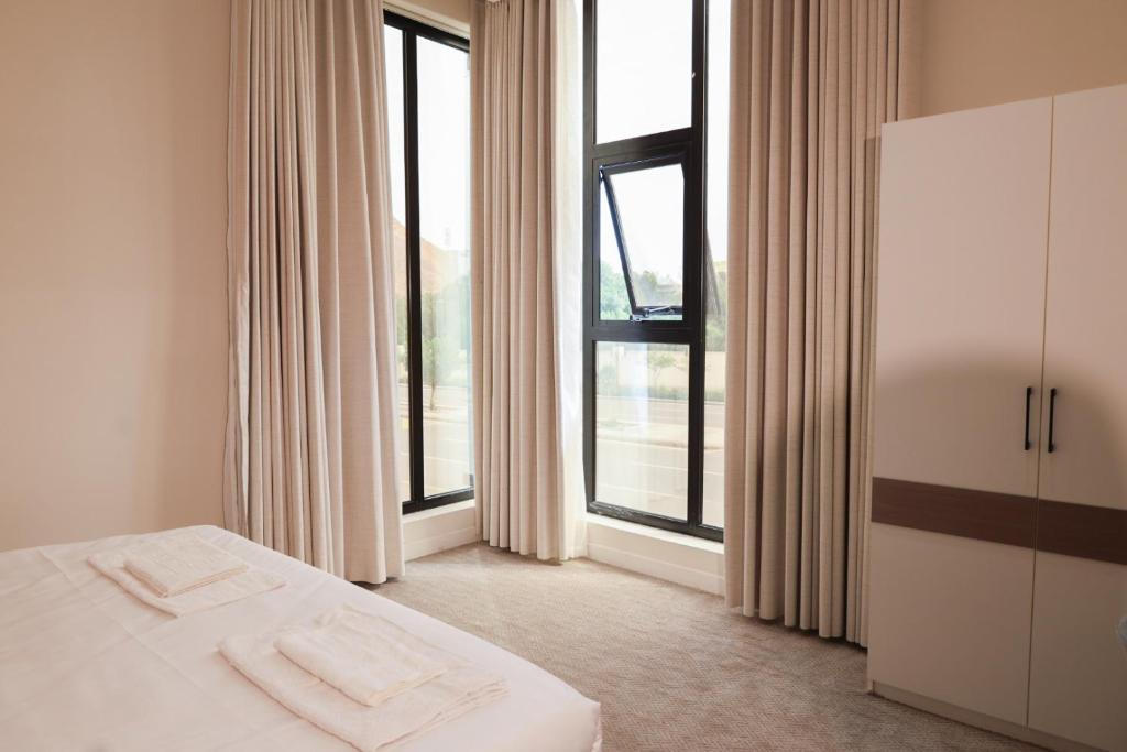 a bedroom with a bed and a large window at رست للشقق المخدومة in Medina
