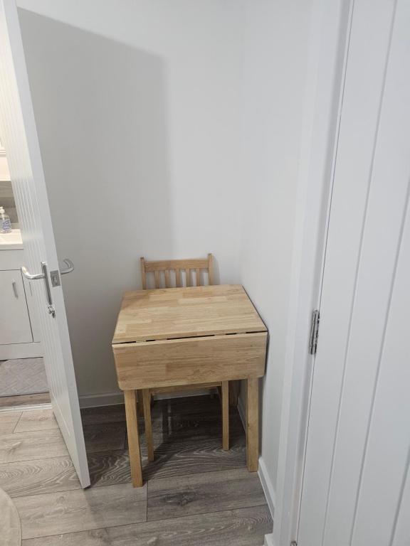a wooden table in the corner of a room at Rose Acre Home Basildon in Basildon