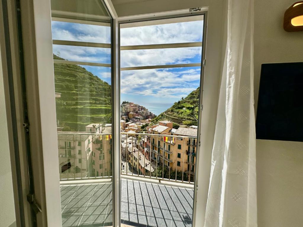 a window with a view of a city at The Manarola Sea View in Manarola