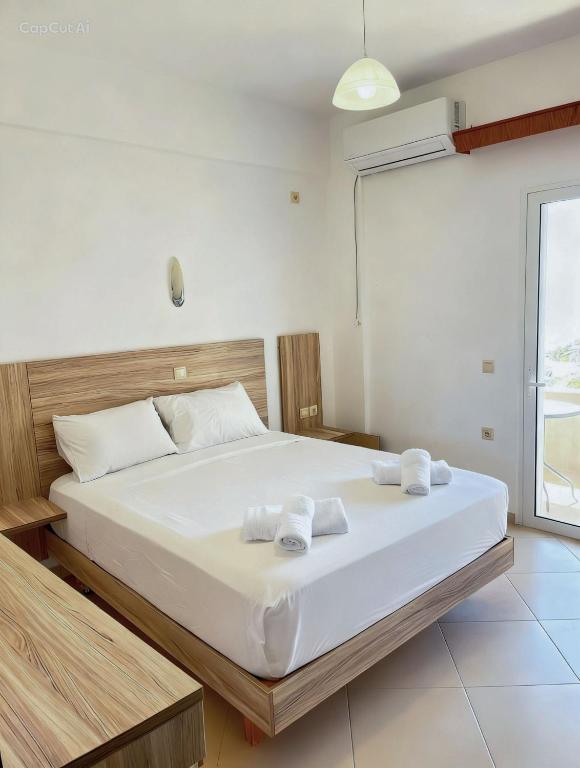 a bedroom with a large bed with towels on it at Kloen Sunset Villa in Sarandë