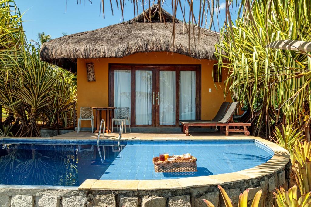 a resort with a swimming pool and a house at Pousada Spa dos Amores in São Miguel do Gostoso